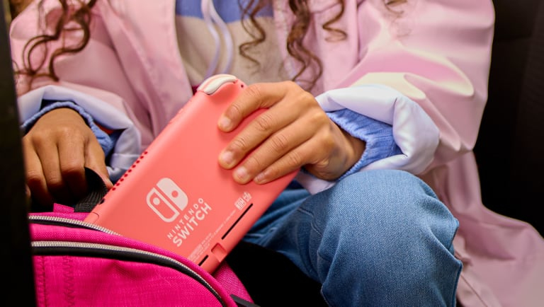 Kind steckt eine Nintendo Switch Lite in den Rucksack